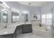 Luxurious bathroom with double sinks, a soaking tub, and a glass-enclosed shower at 11554 Blackmoor Dr, Orlando, FL 32837