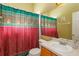 Bathroom featuring single sink vanity, and shower and tub combination with decorative shower curtain at 11554 Blackmoor Dr, Orlando, FL 32837