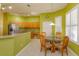 Open-concept kitchen with a dining area featuring a glass table and white shuttered windows at 11554 Blackmoor Dr, Orlando, FL 32837