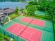 Aerial view of two tennis courts with green and red surfacing with a playground nearby at 1200 Winterberry Lane, Fern Park, FL 32730