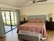 Bright bedroom featuring hardwood floors, ceiling fan, and access to patio at 1200 Winterberry Lane, Fern Park, FL 32730