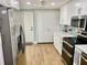 Well-lit kitchen featuring stainless steel appliances, white cabinetry, and hard wood floors at 1200 Winterberry Lane, Fern Park, FL 32730