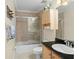 Well-lit bathroom features a vanity with a black countertop, a toilet, and a tiled shower with a glass door at 1243 Osprey Way, Apopka, FL 32712