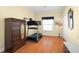 Bedroom with neutral walls, hardwood floors, treadmill, armoire, and natural light at 1243 Osprey Way, Apopka, FL 32712