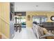 Bright living room flows into the dining area and pool, featuring neutral tile and gray furniture at 1243 Osprey Way, Apopka, FL 32712