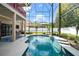 A screened-in pool boasts clear blue water, surrounded by a patio and lush landscaping, ideal for outdoor relaxation at 1243 Osprey Way, Apopka, FL 32712