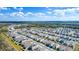 Expansive aerial view of a community showcasing uniform housing and picturesque landscaping with scattered trees at 1260 Berry Ln, Davenport, FL 33837