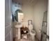 Cozy half bathroom with a pedestal sink and decorative mirror at 14388 Orchild Island Dr, Orlando, FL 32827