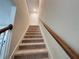 Carpeted staircase with wooden handrail leading to the upper level at 14388 Orchild Island Dr, Orlando, FL 32827