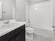 Clean bathroom with a shower-tub combo, white tiling, and a dark vanity at 15574 Murcott Blossom Blvd, Winter Garden, FL 34787