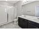 Bright bathroom featuring double sinks, white countertops, and a glass-enclosed shower at 15574 Murcott Blossom Blvd, Winter Garden, FL 34787