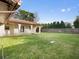 Expansive backyard features a well-manicured lawn, a covered porch, and privacy fencing at 1690 Oneco Ave, Winter Park, FL 32789