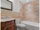 Charming bathroom featuring travertine tile, a wood vanity and a shower-tub combo at 1690 Oneco Ave, Winter Park, FL 32789