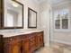 Bathroom featuring granite countertops, dual sinks, antique wood vanity, shutters, and tile floors at 1690 Oneco Ave, Winter Park, FL 32789