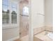 Bathroom showcases a glass walk-in shower, window with shutters, and tiled walls at 1690 Oneco Ave, Winter Park, FL 32789