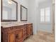 Elegant bathroom boasts a detailed wood vanity with double sinks and travertine tile flooring at 1690 Oneco Ave, Winter Park, FL 32789