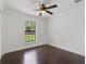 Cozy bedroom features hardwood floors, neutral paint, ceiling fan, and a bright window at 1690 Oneco Ave, Winter Park, FL 32789