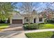 Inviting single-story home with a brick driveway, lush lawn, and a charming terracotta-tiled roof at 1690 Oneco Ave, Winter Park, FL 32789