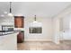 Open kitchen featuring granite countertops, travertine floors, a window, modern lighting, and a breakfast bar at 1690 Oneco Ave, Winter Park, FL 32789