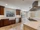 Kitchen with stainless appliances, farmhouse sink, stone tile and island cooktop at 1690 Oneco Ave, Winter Park, FL 32789