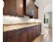 Kitchen featuring dark wood cabinets with granite countertops, stainless appliances, and travertine floors at 1690 Oneco Ave, Winter Park, FL 32789