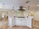 Island cooktop features travertine flooring and white cabinetry at 1690 Oneco Ave, Winter Park, FL 32789