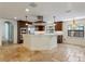Kitchen with travertine flooring, large island, stainless appliances, and custom cabinetry at 1690 Oneco Ave, Winter Park, FL 32789