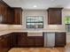 Kitchen with stainless dishwasher, white apron sink, and custom wood cabinets at 1690 Oneco Ave, Winter Park, FL 32789