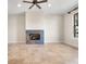 Neutral living room showcasing travertine tile, a tiled fireplace, a ceiling fan, and a window with natural light at 1690 Oneco Ave, Winter Park, FL 32789