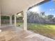 Covered patio features travertine tile, white pillars, and a view of the fenced backyard at 1690 Oneco Ave, Winter Park, FL 32789