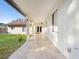 Covered patio has travertine tile, white pillars and a view of the backyard and house at 1690 Oneco Ave, Winter Park, FL 32789