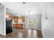 Bright dining area with wood floors, modern chandelier, and views of the kitchen area with wood cabinets at 17445 Hillside Dr, Montverde, FL 34756