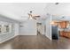 Open-concept living room with wood-look tile flooring and a view of the kitchen and entryway at 17445 Hillside Dr, Montverde, FL 34756