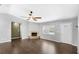 Bright living room features wood-look tile flooring, a ceiling fan, and a cozy corner fireplace at 17445 Hillside Dr, Montverde, FL 34756