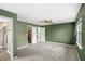 Spacious green-painted main bedroom with carpeted floors, ceiling fan, and adjacent bathroom and closet at 17445 Hillside Dr, Montverde, FL 34756