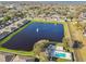 Aerial view of the community featuring a pond, pool, and residential area amidst lush greenery at 1821 Christina Lee Ln, St Cloud, FL 34769