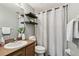 Well-lit bathroom with a neutral color scheme, floating shelves, and a shower with a white curtain at 1821 Christina Lee Ln, St Cloud, FL 34769