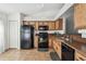 Functional kitchen features black appliances and wood cabinets at 1821 Christina Lee Ln, St Cloud, FL 34769