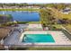 Aerial view of the community pool, playground and lush pond landscape with community homes nearby at 1821 Christina Lee Ln, St Cloud, FL 34769