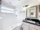 A modern bathroom features a walk-in shower, framed mirror, black marble countertop, and a white toilet at 1970 Larkwood Dr, Apopka, FL 32703