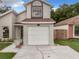 Exterior showcasing a charming two-story home featuring an attached garage and mature landscaping at 1970 Larkwood Dr, Apopka, FL 32703