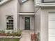 Close up of the front door with a welcome sign, arched window and lush landscaping at 1970 Larkwood Dr, Apopka, FL 32703