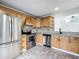 Well-lit kitchen featuring stainless steel appliances, light wood cabinets, and granite countertops at 1970 Larkwood Dr, Apopka, FL 32703