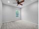 Cozy bedroom features neutral carpet, a ceiling fan, and a window offering natural light at 2137 Blackjack Oak St, Ocoee, FL 34761