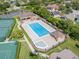 Aerial view of community pool with lounge chairs and covered seating area adjacent to tennis courts at 2137 Blackjack Oak St, Ocoee, FL 34761