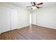 Spacious bedroom with a ceiling fan, closet, and wood flooring at 2339 Foxtree Rd, Tavares, FL 32778