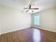 Bedroom with a ceiling fan, wood-look floors, and a window letting in natural light at 2339 Foxtree Rd, Tavares, FL 32778