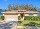 Charming single-story home featuring a two-car garage and well-manicured landscaping at 2339 Foxtree Rd, Tavares, FL 32778