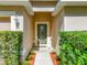 Inviting front entrance with decorative glass door and well-maintained shrubs at 2339 Foxtree Rd, Tavares, FL 32778