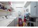 This laundry room has shelving, a door to the outside, and a washer and dryer at 2413 Spingarn Ct, Orlando, FL 32811